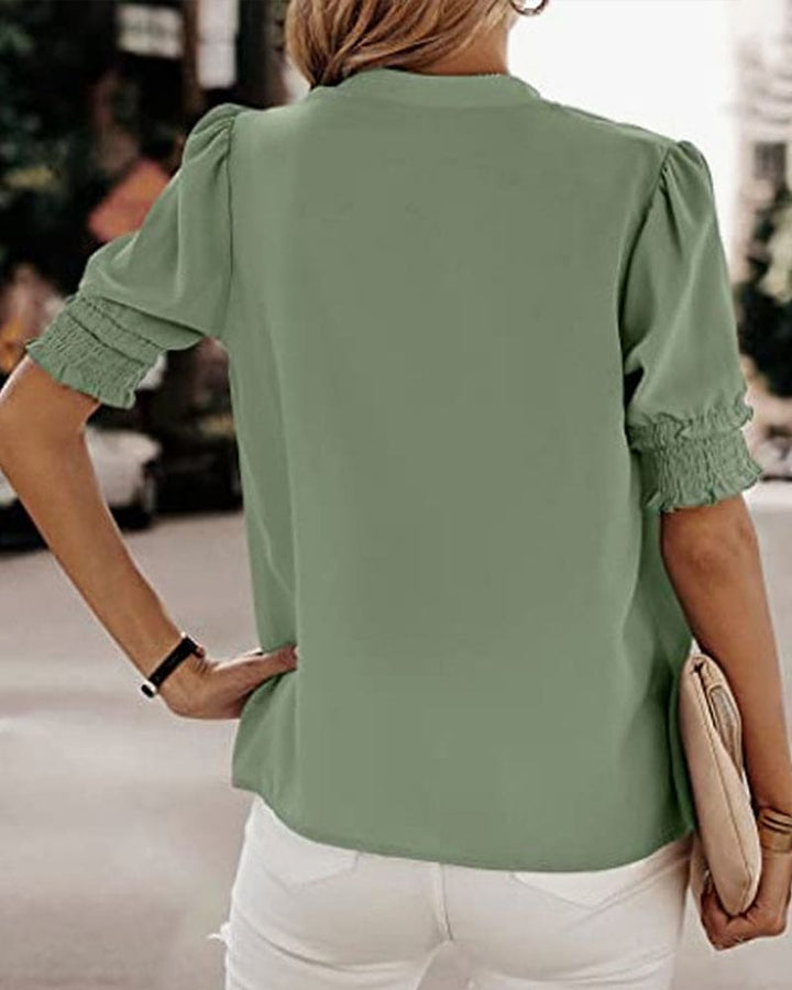 Blouse met een stijlvolle V-hals en trendy korte mouwen. Een veelzijdige aanvulling op je garderobe met een perfecte balans tussen casual en professioneel. Gemaakt van luchtige chiffon en duurzaam polyester voor comfort en stijl. Voorzien van een flatterende V-hals, pofmouwen en een losse pasvorm voor bewegingsvrijheid. Maattabel beschikbaar voor borst, lengte en mouwen.