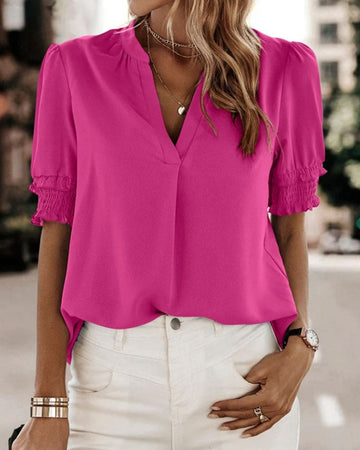 Blouse met een stijlvolle V-hals en trendy korte mouwen. Een veelzijdige aanvulling op je garderobe met een perfecte balans tussen casual en professioneel. Gemaakt van luchtige chiffon en duurzaam polyester voor comfort en stijl. Voorzien van een flatterende V-hals, pofmouwen en een losse pasvorm voor bewegingsvrijheid. Maattabel beschikbaar voor borst, lengte en mouwen.